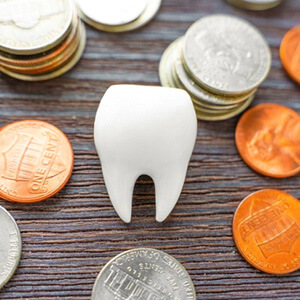 a plastic tooth surrounded by coins