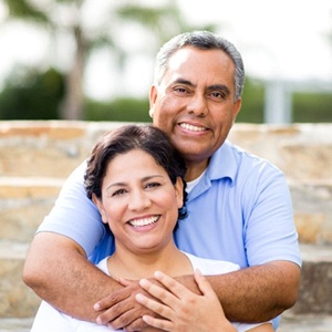 An older couple with dental implants Jupiter smiling outside.