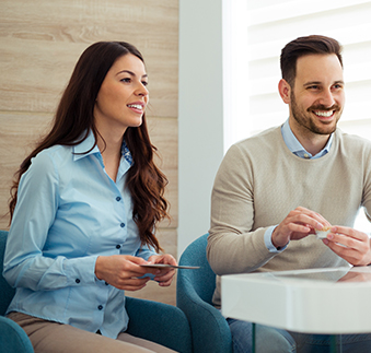 Man and woman talking to person across a desk