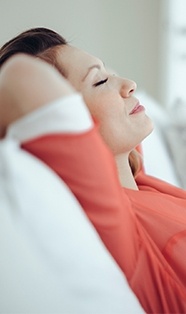 Relaxing woman lying back with hands behind head