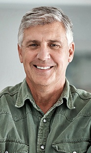 Smiling older man in green collared shirt