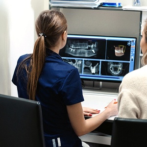 Dental team reviewing scans while preparing for procedure
