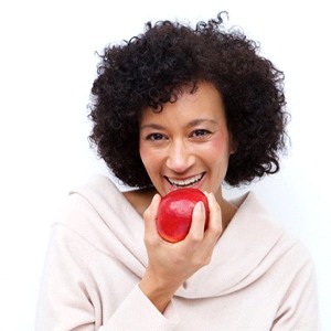 older woman biting into red apple