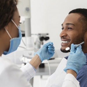 young man smiling at his dentist during a checkup