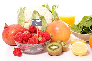Lots of fruits and vegetables on table with sign reading “vitamin C”