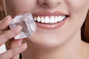 Woman with dental implants near Wellington holding an ice cube