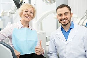 An older woman and her oral surgeon pleased with the results of the dental implant placement in Palm Beach Gardens