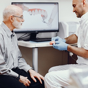 Senior man talking to oral surgeon, getting information about implant dentures
