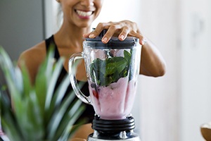 Woman blending fruits and vegetables for a smoothie