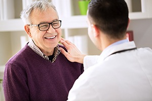 Man with dental implants in Jupiter speaking with his dentist