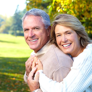 An older couple smiling outside.