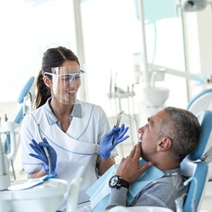 A dentist speaking with a dental patient.