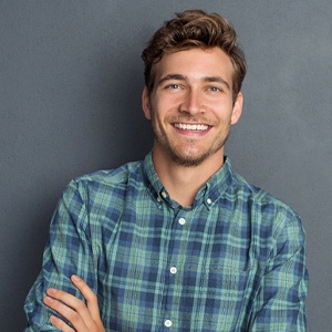 A man smiling and folding his arms.