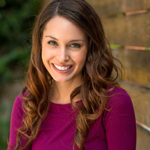 A woman smiling outside.