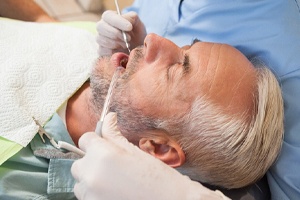 Middle-aged man laying in dental chair during treatment