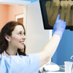 A woman looking at an X-ray with a dentist.