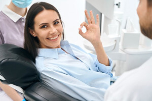 a patient smiling and giving a thumbs up