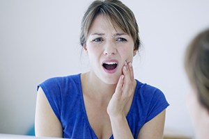 Woman holding cheek in pain