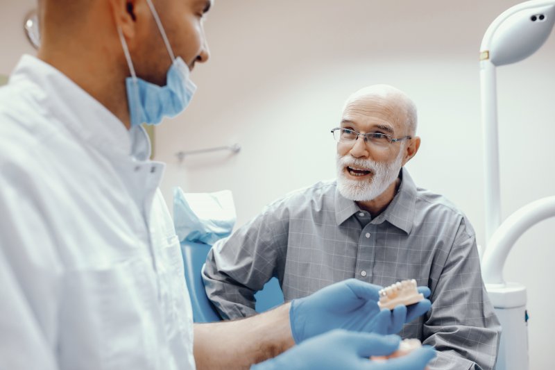 A man asking a dentist about dental implants.