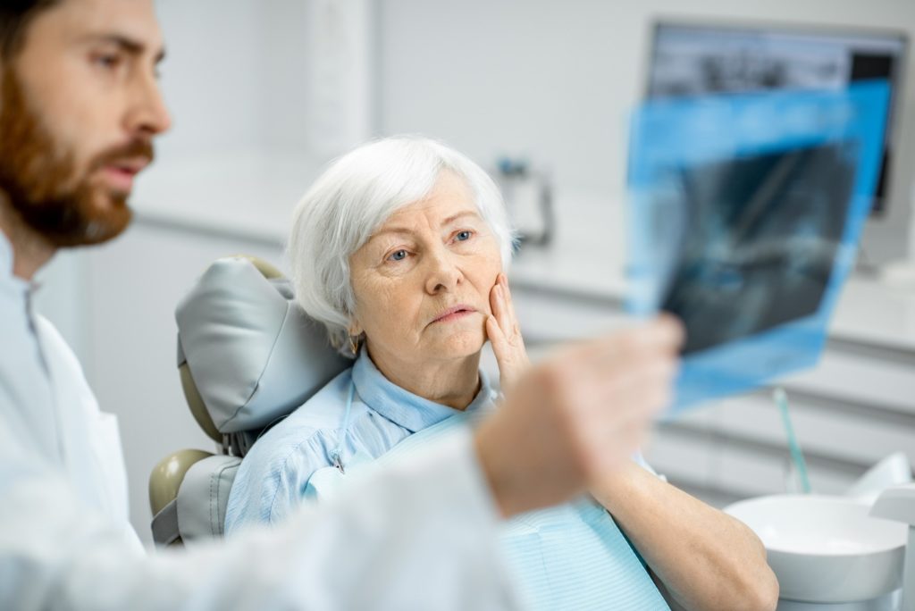 Oral surgeon showing patient X-rays