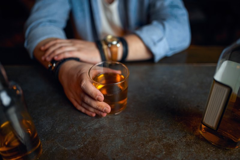 man drinking alcohol after tooth extraction