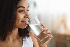 woman drinking clear liquid as a diet restriction for All-On-4 implants