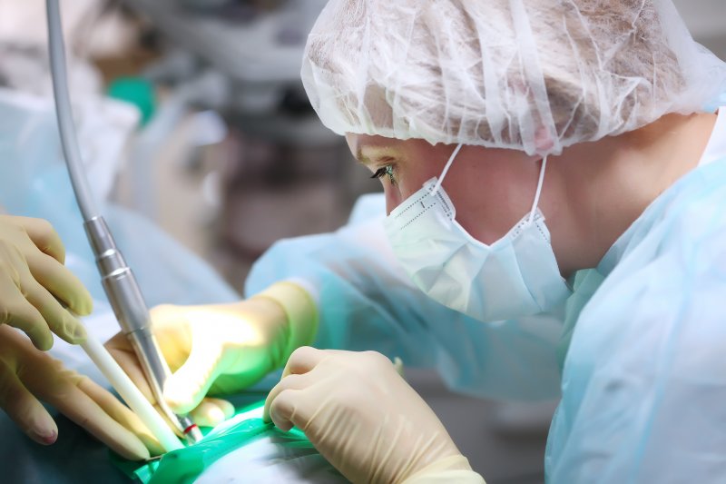 Dentist performing surgery after administering general anesthesia to patient