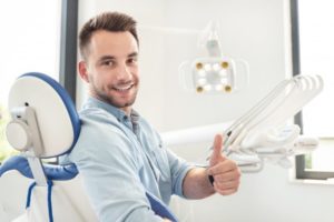 Man at the dentist giving a thumbs up before his wisdom tooth extraction.
