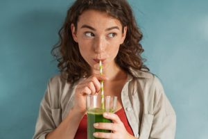 A patient drinking a smoothie after her wisdom tooth extractions in Royal Palm Beach