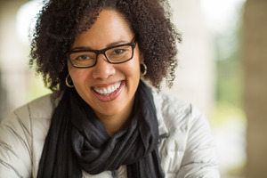Adult woman smiling with glasses and a scarf