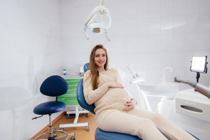 Pregnant oral surgery patient sitting in chair