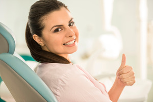 Female patient with ponytail giving a thumbs up