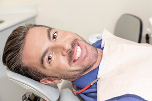 Male patient lying down in a dental chair and smiling