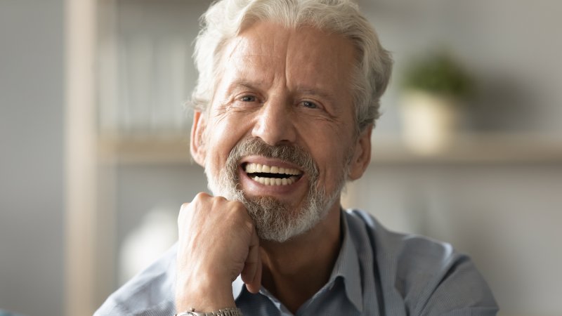 Older man smiling with his dental implants